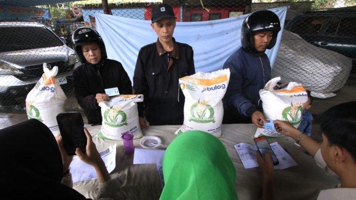 Petugas mendokumentasikan warga penerima manfaat saat penyaluran program Bantuan Pangan Cadangan Beras Pemerintah (CBP) Tahap III Tahun 2024 di bawah flyover Mochtar Kusumaatmadja (Pasupati), Kelurahan Tamansari, Kecamatan Bandung Wetan, Kota Bandung, Jawa Barat, Selasa (11/12/2024).