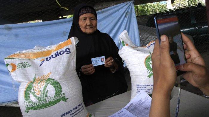 Petugas mendokumentasikan warga penerima manfaat saat penyaluran program Bantuan Pangan Cadangan Beras Pemerintah (CBP) Tahap III Tahun 2024 di bawah flyover Mochtar Kusumaatmadja (Pasupati), Kelurahan Tamansari, Kecamatan Bandung Wetan, Kota Bandung, Jawa Barat, Selasa (11/12/2024).