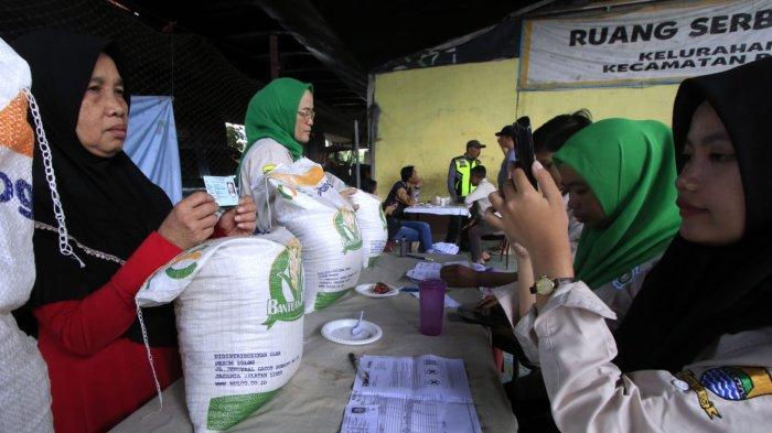Petugas mendokumentasikan warga penerima manfaat saat penyaluran program Bantuan Pangan Cadangan Beras Pemerintah (CBP) Tahap III Tahun 2024 di bawah flyover Mochtar Kusumaatmadja (Pasupati), Kelurahan Tamansari, Kecamatan Bandung Wetan, Kota Bandung, Jawa Barat, Selasa (11/12/2024).