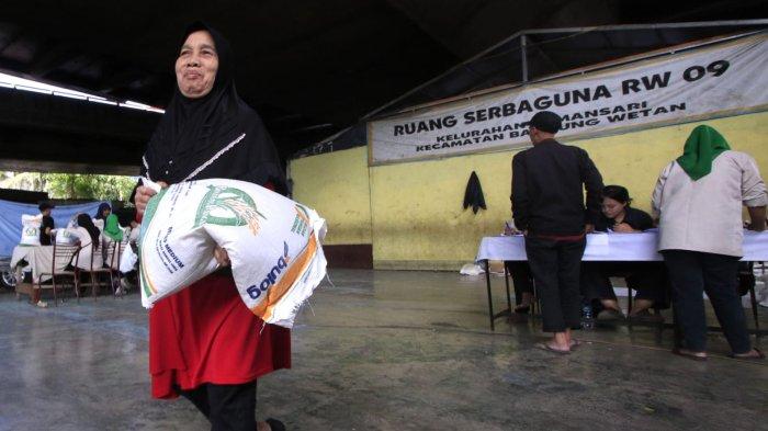 Warga penerima manfaat menerima beras saat penyaluran program Bantuan Pangan Cadangan Beras Pemerintah (CBP) Tahap III Tahun 2024 di bawah flyover Mochtar Kusumaatmadja (Pasupati), Kelurahan Tamansari, Kecamatan Bandung Wetan, Kota Bandung, Jawa Barat, Selasa (11/12/2024).