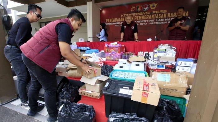 Petugas membereskan barang bukti seusai Konferensi Pers Pengungkapan Clandestine Lab Narkotika, di rumah yang berhasil digerebek, Podomoro Park Cluster Amagriya Eka 09 No 27, Kecamatan Bojongsoang, Kabupaten Bandung, Jawa Barat, Kamis (12/12/2024).