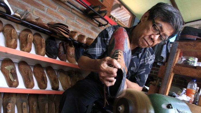 Perajin mengerjakan pembuatan sampel sepatu yang terbuat dari bahan baku utama olahan limbah kulit kaki (ceker) ayam di rumah produksi Hirka Shoes, Gang Subur, Jalan Mohammad Toha, Kelurahan Cigereleng, Kecamatan Regol, Kota Bandung, Jawa Barat, Selasa (17/12/2024).