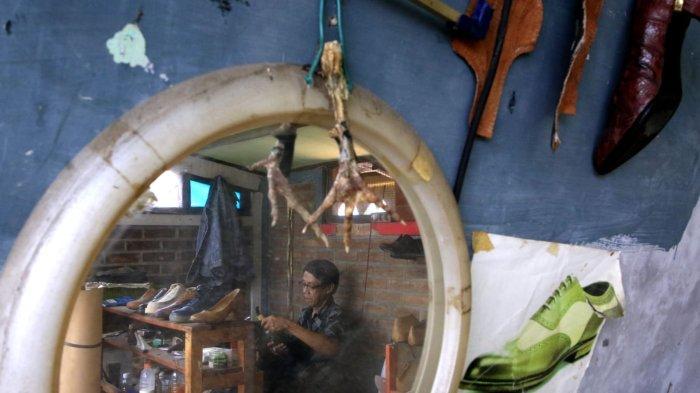 Perajin mengerjakan pembuatan sampel sepatu yang terbuat dari bahan baku utama olahan limbah kulit kaki (ceker) ayam di rumah produksi Hirka Shoes, Gang Subur, Jalan Mohammad Toha, Kelurahan Cigereleng, Kecamatan Regol, Kota Bandung, Jawa Barat, Selasa (17/12/2024).
