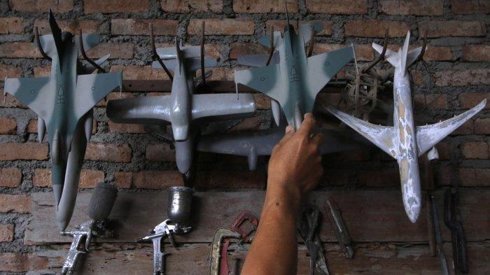 Owner Tiara Flight Miniature, Deden Sopian (55) mengerjakan pembuatan miniatur pesawat terbang dari bahan baku resin di rumah produksinya, Jalan KH Usman Dhomiri, Desa Padasuka, Kecamatan Cimahi Tengah, Kota Cimahi, Jawa Barat, Rabu (18/12/2024).
