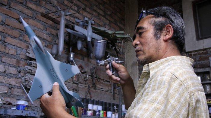 Owner Tiara Flight Miniature, Deden Sopian (55) mengerjakan pembuatan miniatur pesawat terbang dari bahan baku resin di rumah produksinya, Jalan KH Usman Dhomiri, Desa Padasuka, Kecamatan Cimahi Tengah, Kota Cimahi, Jawa Barat, Rabu (18/12/2024).