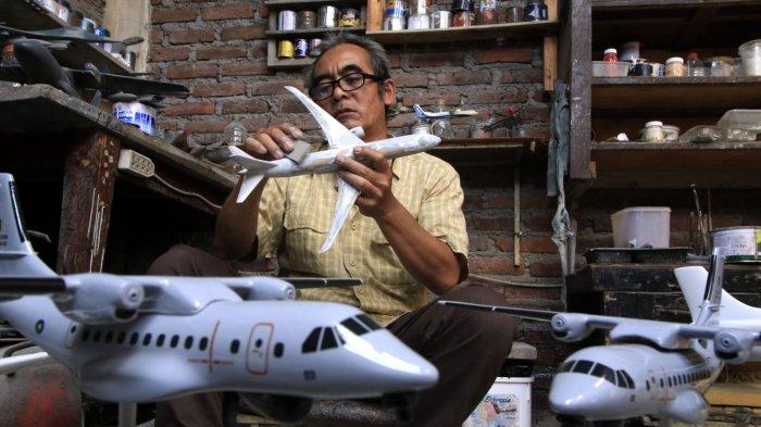 Owner Tiara Flight Miniature, Deden Sopian (55) mengerjakan pembuatan miniatur pesawat terbang dari bahan baku resin di rumah produksinya, Jalan KH Usman Dhomiri, Desa Padasuka, Kecamatan Cimahi Tengah, Kota Cimahi, Jawa Barat, Rabu (18/12/2024).
