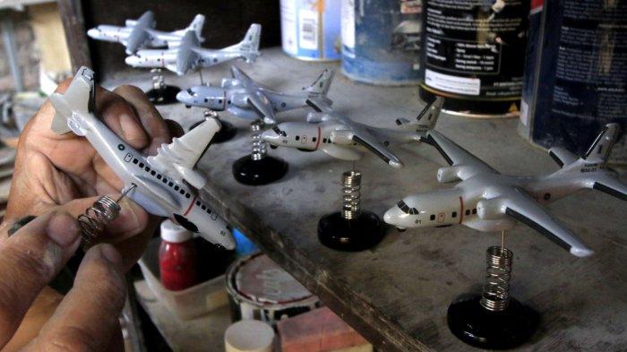 Owner Tiara Flight Miniature, Deden Sopian (55) mengerjakan pembuatan miniatur pesawat terbang dari bahan baku resin di rumah produksinya, Jalan KH Usman Dhomiri, Desa Padasuka, Kecamatan Cimahi Tengah, Kota Cimahi, Jawa Barat, Rabu (18/12/2024).