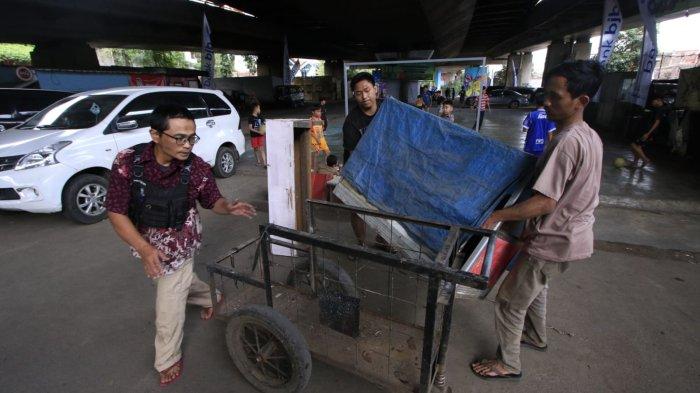 Sejumlah warga mengangkut etalase untuk berjulanan di lahan yang sudah mulai sedikit tertata di kolong Flyover Mochtar Kusumaatmadja (Pasupati), Kelurahan Tamansari, Kecamatan Bandung Wetan, Kota Bandung, Jumat (20/12/2024).