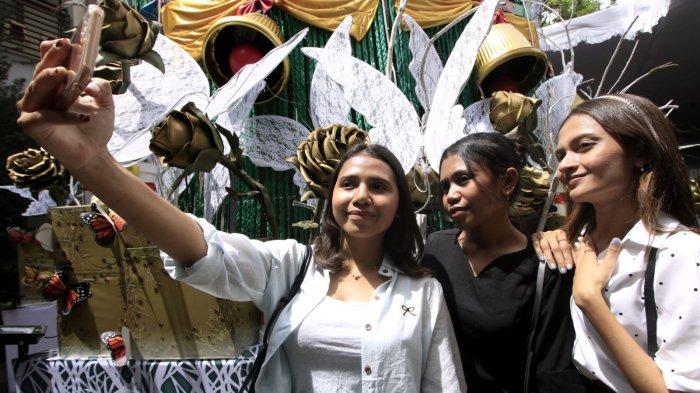 Umat kristiani berswafoto di depan pohon Natal selesai melaksanakan ibadah misa pada Hari Natal 2024 di Gereja Katedral Santo Petrus, Jalan Merdeka, Kota Bandung, Jawa abarat, Rabu (25/12/2024).