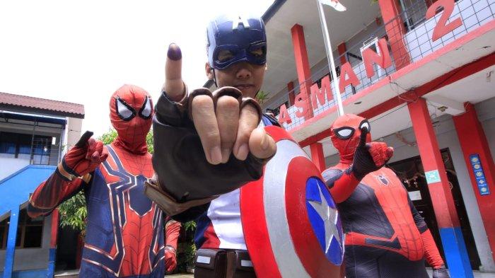 Petugas berkostum Superhero memperlihatkan jarinya yang sudah dicelupkan ke tinta seusai menggunakan hak pilihnya di Tempat Pemungutan Suara (TPS) 12 pada pelaksanaan Pemilihan Kepala Daerah (Pilkada) Serentak 2024, di RT 03 RW 03, Kampung Babakan Loa, Kelurahan Pasirkaliki, Kota Cimahi, Jawa Barat, Rabu (27/11/2024).