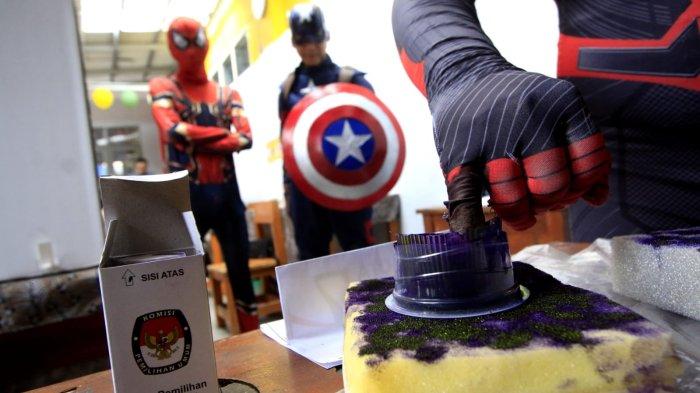 Petugas berkostum Superhero mencelupkan jari tangannya ke tinta seusai menggunakan hak pilihnya di Tempat Pemungutan Suara (TPS) 12 pada pelaksanaan Pemilihan Kepala Daerah (Pilkada) Serentak 2024, di RT 03 RW 03, Kampung Babakan Loa, Kelurahan Pasirkaliki, Kota Cimahi, Jawa Barat, Rabu (27/11/2024).