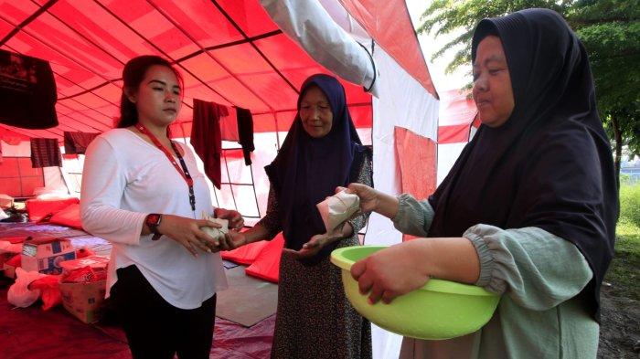 Warga terdampak banjir menerima nasi bungkus di tenda pengungsian di Taman Air, Kampung Cijagra, RW 10, Desa/Kecamatan Bojongsoang, Kabupaten Bandung, Jawa Barat, Jumat (29/11/2024).