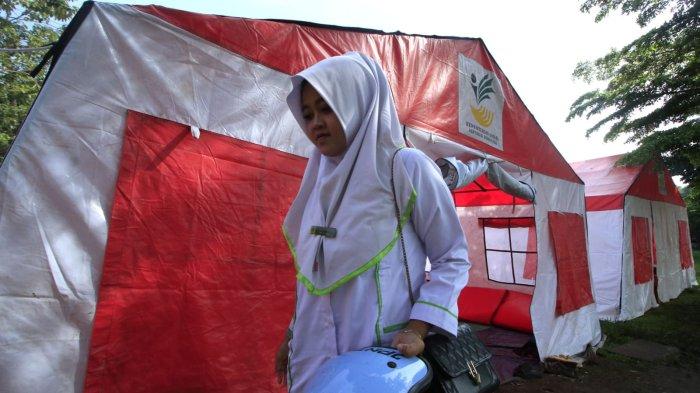 Seorang warga terdampak banjir berangkat kuliah dari tenda pengungsian 
di Taman Air, Kampung Cijagra, RW 10, Desa/Kecamatan Bojongsoang, Kabupaten Bandung, Jawa Barat, Jumat (29/11/2024).