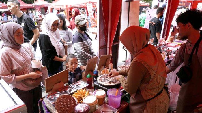 Pengunjung membeli jajanan pada gelaran Bandung Seuhah Festival 2024, di area parkir Balai Kota Bandung, Jalan Wastukencana, Kota Bandung, Jawa Barat, Sabtu (30/11/2024).