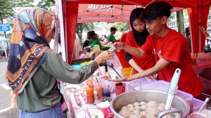 Pengunjung membeli jajanan pada gelaran Bandung Seuhah Festival 2024, di area parkir Balai Kota Bandung, Jalan Wastukencana, Kota Bandung, Jawa Barat, Sabtu (30/11/2024).
