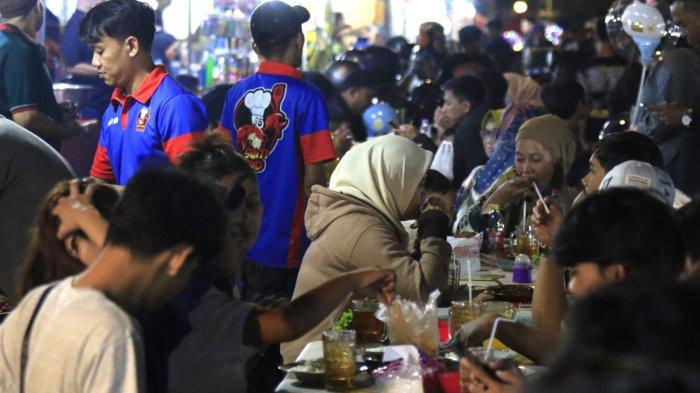 Sejumlah warga yang akan merayakan tahun baru 2025 makan di kawasan Jalan Cikapundung Barat, Kota Bandung, Jawa Barat, Selasa (31/12/2024) malam.