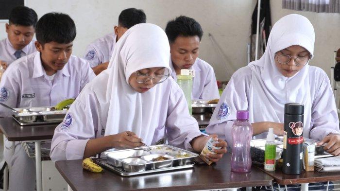 Pelajar menyantap makanan sehat bergizi dalam program Makan Bergizi Gratis (MBG) hari pertama, di SMA Angkasa, Lanud Husein Sastranegara, Kota Bandung, Jawa Barat, Senin (6/1/2025).