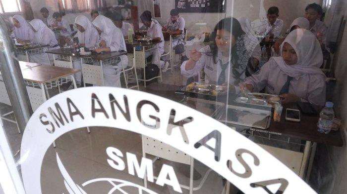 Pelajar menyantap makanan sehat bergizi dalam program Makan Bergizi Gratis (MBG) hari pertama, di SMA Angkasa, Lanud Husein Sastranegara, Kota Bandung, Jawa Barat, Senin (6/1/2025).