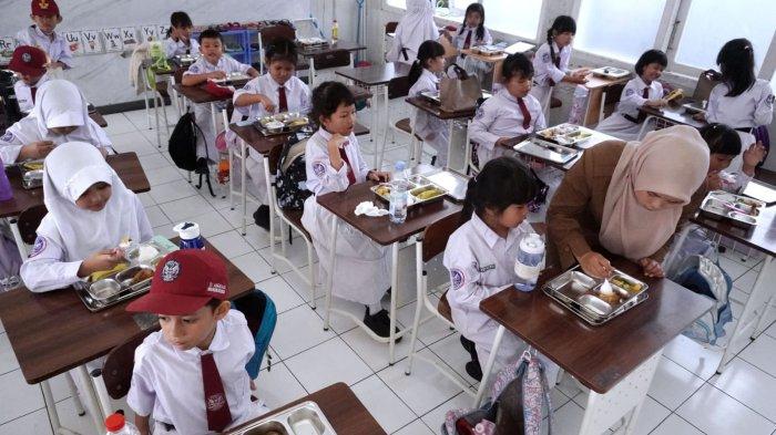 Pelajar menyantap makanan sehat bergizi dalam program Makan Bergizi Gratis (MBG) hari pertama, di SD Angkasa, Lanud Husein Sastranegara, Kota Bandung, Jawa Barat, Senin (6/1/2025).