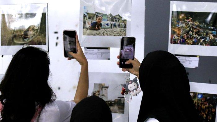 Pengunjung memotret salah satu foto pada gelaran Pameran Foto Urban Visual: Kampung Braga bertema 