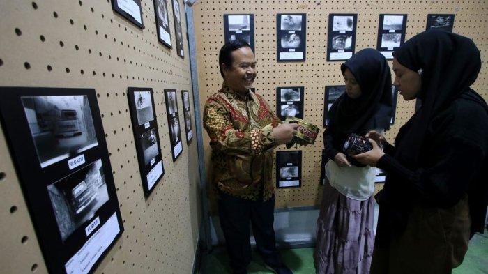 Ketua Program Studi (Kaprodi) Fotografi dan Film Universitas Pasundan (Unpas), Rahmadi (kiri) menjelaskan kamera lubang jarum kepada pengunjung pada gelaran Pameran Foto Urban Visual: Kampung Braga di Gedung Bandung Creative Hub, Jalan Laswi, Kota Bandung, Jawa Barat, Selasa (21/1/2025).
