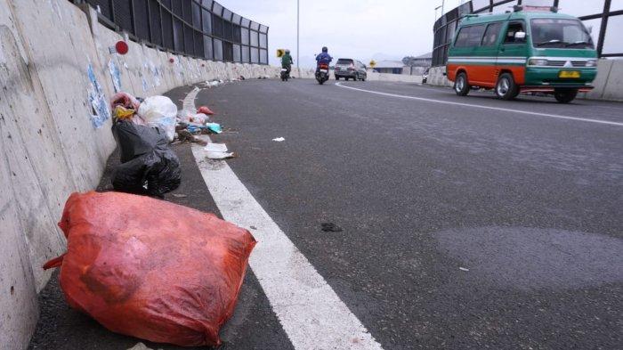 Kendaraan bermotor melintasi sampah di Flyover Ciroyom, Kelurahan Ciroyom, Kecamantan Andir, Kota Bandung, Jawa Barat, Jumat (24/1/2025).
