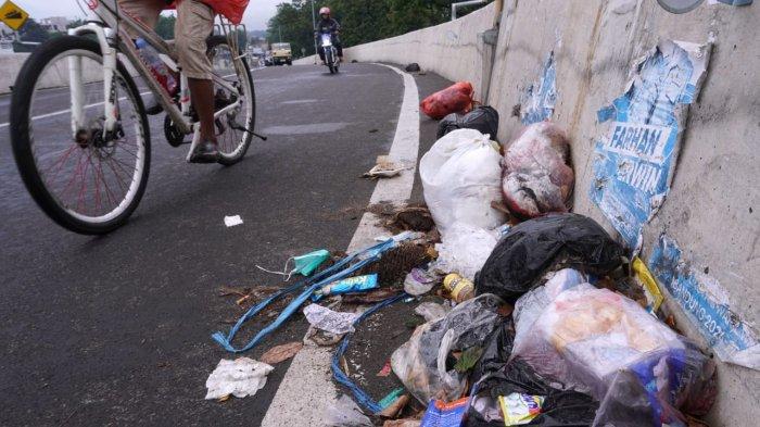 Kendaraan bermotor melintasi sampah di Flyover Ciroyom, Kelurahan Ciroyom, Kecamantan Andir, Kota Bandung, Jawa Barat, Jumat (24/1/2025).