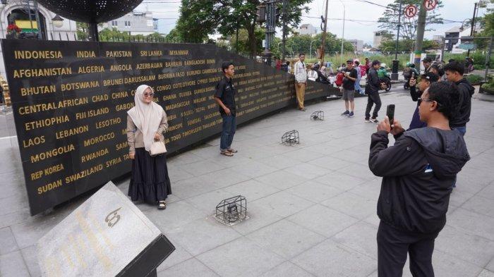 Sejumlah wisatawan berfoto di depan Monumen Solidaritas Asia Afrika saat mengisi liburan di Jalan Asia Afrika, Kota Bandung, Jawa Barat, Senin (27/1/2025).