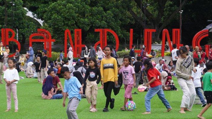 Sejumlah anak bermain bola saat mengisi liburan di lapangan rumput sintetis taman Alun-Alun Kota Bandung, Jawa Barat, Selasa (28/1/2025).