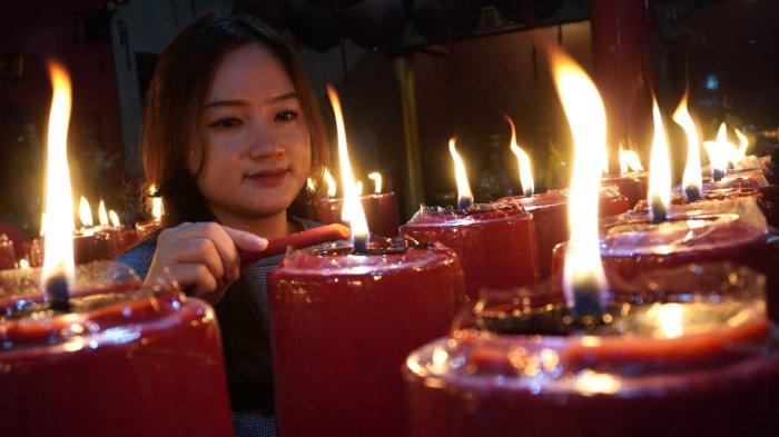 Warga keturunan Tionghoa menyalakan lilin setelah melaksanakan sembahyang malam di Vihara Dharma Ramsi, Gang Ibu Aisah, Jalan Cibadak, Kota Bandung, Jawa Barat, Selasa (28/1/2025).