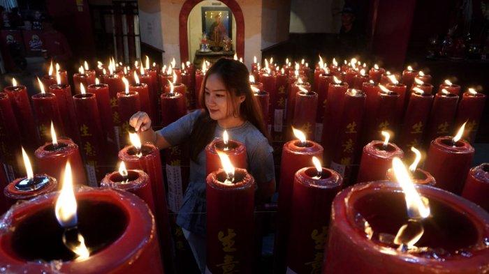 Warga keturunan Tionghoa menyalakan lilin setelah melaksanakan sembahyang malam di Vihara Dharma Ramsi, Gang Ibu Aisah, Jalan Cibadak, Kota Bandung, Jawa Barat, Selasa (28/1/2025).