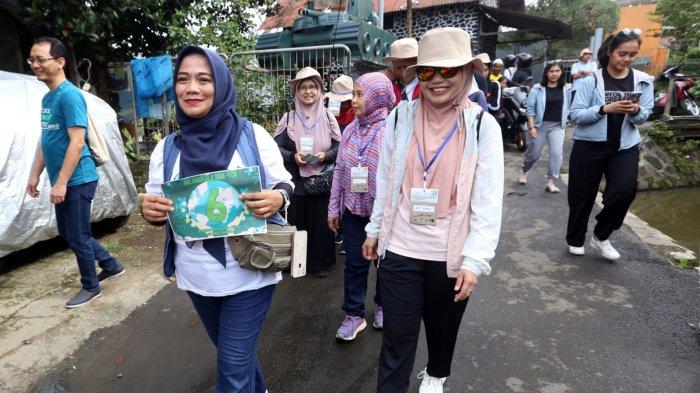 Civitas akademik SBM ITB dan anggota komunitas Circular Dago melintas di kawasan permukiman sepanjang Sungai Cikapundung saat melakukan kegiatan SurGa Hijau (Susur Gang Hijau) dalam rangkaian acara perayaan hari ulang tahun ke-21 SBM ITB di Kota Bandung, Jawa Barat, Jumat (31/1/2025).