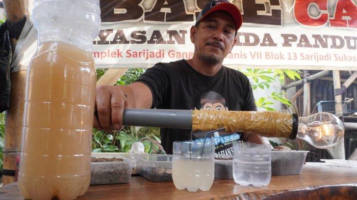 Petugas pengelola sampah Baraya Sabar, Herwin (49) memperlihatkan daya penerangan lampu lebih terang saat diberi cairan mikroorganisme lokal (MOL) di Base Camp Baraya Sabar, RW 07, Kelurahan Sarijadi, Kecamatan Sukasari, Kota Bandung, Jawa Barat, Selasa (4/2/2025).
