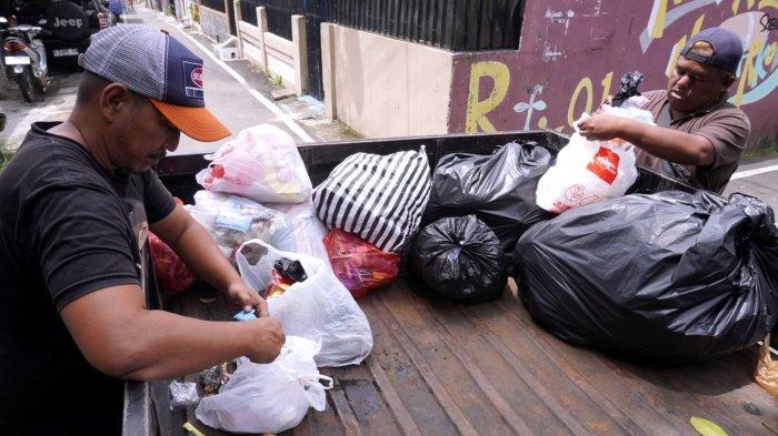 Petugas pengelola sampah Baraya Sabar, Herwin (49) dan Endi Rohaendi (30) memilah sampah anorganik bernilai ekonomi dan residu di mobil pengangkut sampah saat menarik sampah dari warga di RW 07, Kelurahan Sarijadi, Kecamatan Sukasari, Kota Bandung, Jawa Barat, Selasa (4/2/2025).