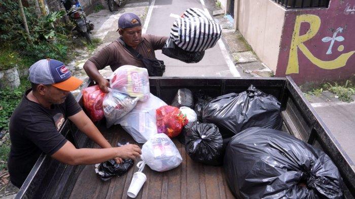 Petugas pengelola sampah Baraya Sabar, Herwin (49) dan Endi Rohaendi (30) memasukan sampah yang sudah diambil dari warga ke mobil sampah di RW 07, Kelurahan Sarijadi, Kecamatan Sukasari, Kota Bandung, Jawa Barat, Selasa (4/2/2025).