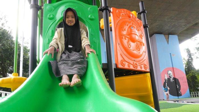 Anak kecil bermain perosotan di Taman Film bawah Flyover Mochtar Kusumaatmadja atau Flyover Pasupati, Kecamatan Bandung Wetan, Kota Bandung, Jawa Barat, Selasa (11/2/2025).