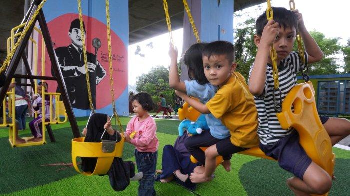 Anak kecil bermain ayunan didampingi orang tuanya di Taman Film bawah Flyover Mochtar Kusumaatmadja atau Flyover Pasupati, Kecamatan Bandung Wetan, Kota Bandung, Jawa Barat, Selasa (11/2/2025).