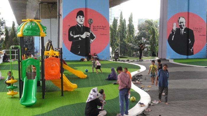 Orang tua mendampingi anaknya bermain di Taman Film bawah Flyover Mochtar Kusumaatmadja atau Flyover Pasupati, Kecamatan Bandung Wetan, Kota Bandung, Jawa Barat, Selasa (11/2/2025).
