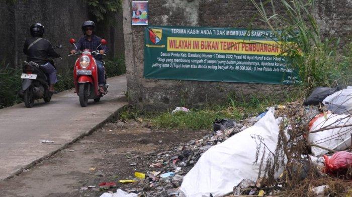 Pengendara bermotor melintasi spanduk bertuliskan himbauan untuk tidak membuang sampah sembarangan di Jalan Citra, Desa Cangkuang Wetan, Kecamatan Dayeuhkolot, Kabupaten Bandung, Jawa Barat, Selasa (18/2/2025).