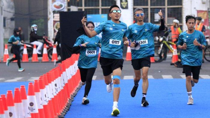 Sejumlah peserta berlari memasuki garis finish dalam ajang PLN Jabar Smile Run 2025, di Jalan Ir Sukarno, kawasan Gedung Merdeka, Kota Bandung, Jawa Barat, Minggu (23/2/2025).