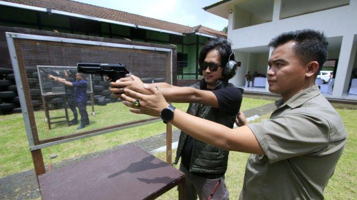 Perwakilan PT Eigerindo, Farid Airlangga (kedua kanan) mengarahkan pistol ke sasaran sebelum melakukan penembakan dalam kegiatan Menembak Bersama EIGER di Lapang Tembak Pistol Arupadatu Gunner Tanker Yonarmed 4/Parahyangan, Jalan Gatot  Subroto, Kota Cimahi, Jawa Barat, Kamis (27/2/2025).