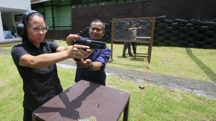 Pasi Intel Yonarmed 4/Parahyangan, Kapten Arm. Sugiyanto mendampingi Product Manager EIGER TAC yang juga Atlet menembak andalan Indonesia, Sarah Ayu Tamaela saat akan melakukan penembakan dalam kegiatan Menembak Bersama EIGER di Lapang Tembak Pistol Arupadatu Gunner Tanker Yonarmed 4/Parahyangan, Jalan Gatot  Subroto, Kota Cimahi, Jawa Barat, Kamis (27/2/2025).