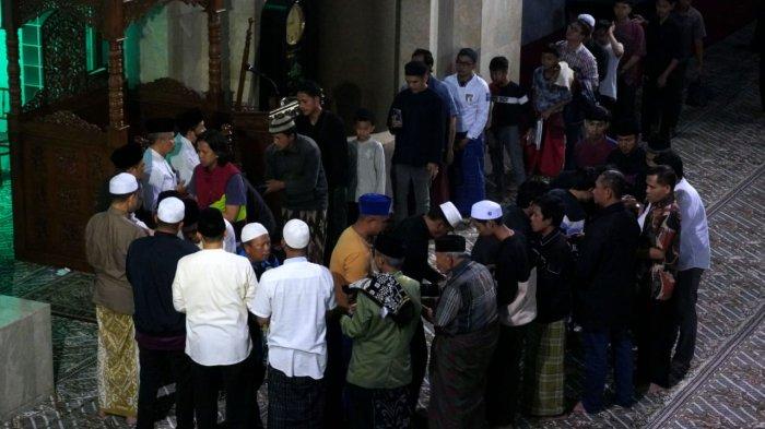 Jemaah bersalaman seusai melaksanakan salat tarawih perdana di Masjid Raya Bandung Provinsi Jawa Barat, Alun-Alun Kota Bandung, Jawa Barat, Jumat (28/2/2025).