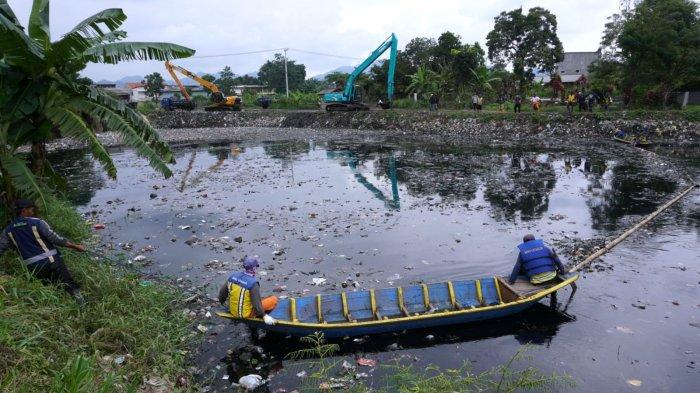 Petugas dari Dinas sumber Daya Air (SDA) Provinsi Jawa Barat dan Balai Besar Wilayah Sungai Citarum (BBWS) menggunakan alat berat jenis beko mengeruk sampah dari Oxbow Cicukang aliran Sungai Citarum, di Kampung Cicukang, Desa Mekarrahayu, Kecamatan Margaasih, Kabupaten Bandung, Jawa Barat, Senin (3/3/2025).