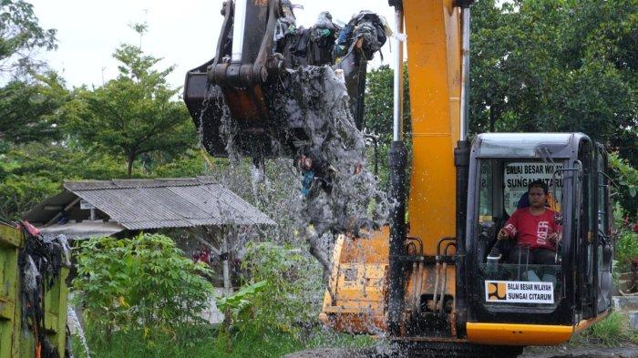 Petugas dari Dinas sumber Daya Air (SDA) Provinsi Jawa Barat dan Balai Besar Wilayah Sungai Citarum (BBWS) menggunakan alat berat jenis beko mengeruk sampah dari Oxbow Cicukang aliran Sungai Citarum, di Kampung Cicukang, Desa Mekarrahayu, Kecamatan Margaasih, Kabupaten Bandung, Jawa Barat, Senin (3/3/2025).