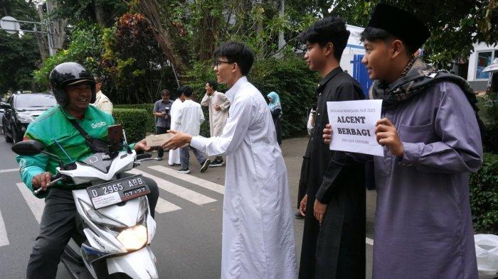 Sejumlah pelajar SMA Alfa Centauri berbagi takjil kepada warga pengguna jalan di Jalan Diponegoro, Kota Bandung, Jawa Barat, Selasa (2/3/2025).