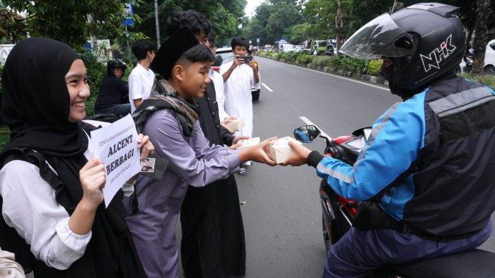 Sejumlah pelajar SMA Alfa Centauri berbagi takjil kepada warga pengguna jalan di Jalan Diponegoro, Kota Bandung, Jawa Barat, Selasa (2/3/2025).