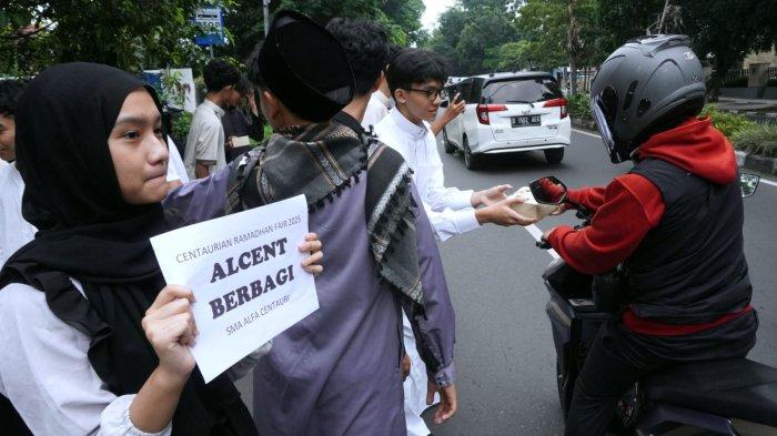 Sejumlah pelajar SMA Alfa Centauri berbagi takjil kepada warga pengguna jalan di Jalan Diponegoro, Kota Bandung, Jawa Barat, Selasa (2/3/2025).