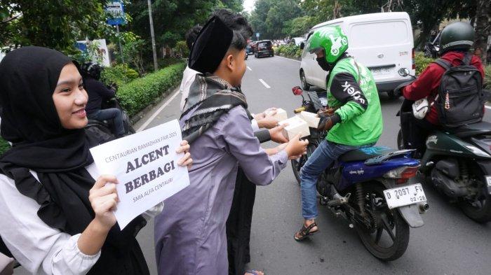 Sejumlah pelajar SMA Alfa Centauri berbagi takjil kepada warga pengguna jalan di Jalan Diponegoro, Kota Bandung, Jawa Barat, Selasa (2/3/2025).
