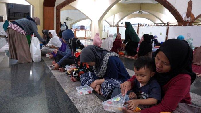 Petugas membagikan takjil gratis kepada warga menjelang waktu berbuka puasa, di Masjid Pusat Dawah Islam Jawa Barat (Pusdai Jabar), Jalan Diponegoro, Kota Bandung, Jawa Barat, Kamis (6/3/2025).